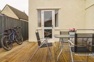 赛伦塞斯特Private deck with newly refurbished flat attached!的一个带桌椅和自行车的庭院