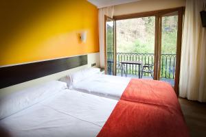埃特克萨拉尔文塔德埃萨拉尔酒店的一间带2张白色床的卧室和一个阳台