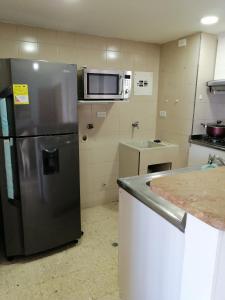 卡塔赫纳Apartamento mar的厨房配有不锈钢冰箱和微波炉。