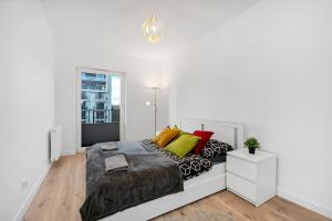 罗兹Luxury in City -2-Bright-Secure&FreeParking的白色卧室配有一张带彩色枕头的大床