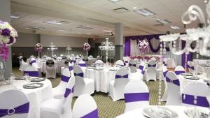 麦克默里堡优异套房酒店 的宴会厅配有白色桌子和紫色椅子