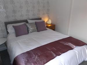惠特比The Granby hotel的一张带紫色和白色床单及枕头的床