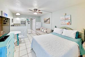 圣徒皮特海滩Pass-A-Grille Beach Retreat Unit 8的一间带大床的卧室和一间厨房