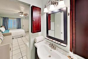 圣徒皮特海滩Pass-A-Grille Beach Retreat Unit 8的一间带水槽和镜子的浴室以及一张床