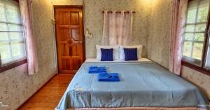 库德岛TA YAI HOMESTAY (ตา ยาย โฮมสเตย์)的一间卧室配有一张带蓝色床单的大床