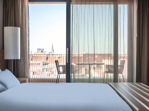 巴塞尔欧洲巴塞尔铂尔曼酒店的一间卧室设有一张床,享有阳台的景色