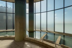 恩纳冲绳太阳码头喜来登度假酒店的一座带玻璃窗的建筑中的游泳池