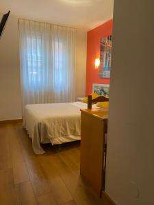 希洪绿色海岸酒店的一间卧室配有一张床、一张书桌和一个窗户。