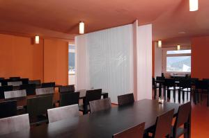 达沃斯达沃斯青年旅舍的一间会议室,配有桌椅和大屏幕