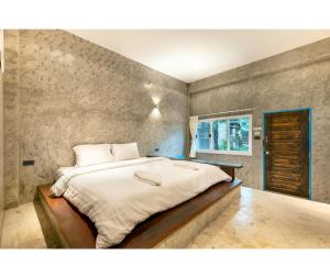 班佩Mac Garden Resort的一张大床,位于一个石墙房间内