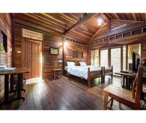 班佩Mac Garden Resort的卧室配有一张床铺,位于带木墙的房间内