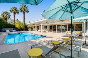 棕榈泉Serenity in Sunmor Permit# 4761的一个带桌椅和遮阳伞的游泳池