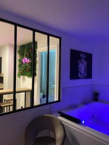 贝桑松L’appart[é] BLACK superbe appartement pop !的紫色浴室设有浴缸和椅子