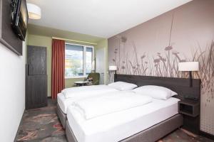蒂罗尔州霍尔希韦斯特酒店的一间卧室设有两张床和鲜花墙