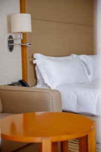 索哈尔索哈尔皇冠假日酒店的带沙发、床和桌子的客房