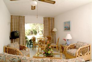 布里奇敦梅花树俱乐部公寓的客厅配有沙发、椅子和桌子