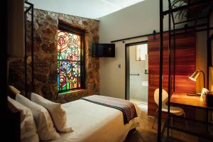 IreneBastion House的一间卧室设有一张床和一个彩色玻璃窗
