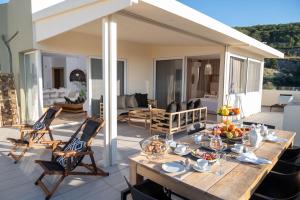罗希姆诺Helen Luxury Holiday House with Sea View的享有房屋景致的天井上的餐桌