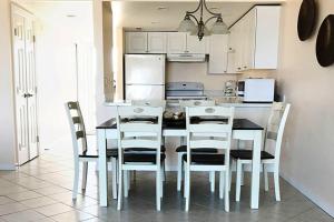大洋城Ocean Hideaway的厨房配有桌椅和冰箱。