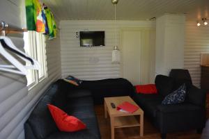 Lumparland斯维诺海边别墅的客厅配有两张黑色沙发和一张桌子