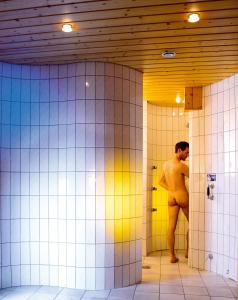 涅德劳奥地利酒店的赤身裸体的人站在浴室摊位