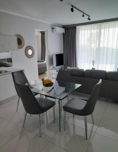 米德兰Waterfall Luxury Apartment的客厅配有玻璃桌和椅子