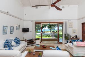 MaziziniTamarind Tree Zanzibar的客厅配有白色家具和大窗户