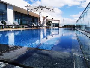 比勒陀利亚Trilogy Apartment - Sapphire Gold的一座大楼顶部的游泳池,配有椅子和遮阳伞