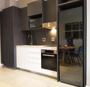 比勒陀利亚Trilogy Apartment - Sapphire Gold的厨房配有白色橱柜、炉灶和桌子。