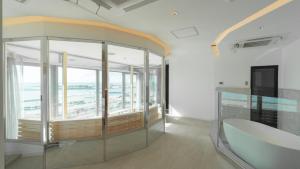 石垣岛THIRD ishigakijima的客房设有大窗户和玻璃桌