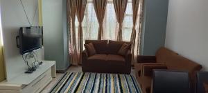 哥打巴鲁Caliph Suite Apartment Homestay Anjung Vista Kubang Kerian的带沙发和电视的客厅