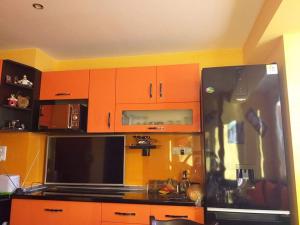 斯利文Apartament Kostov Sliven的厨房配有橙色橱柜和黑色冰箱