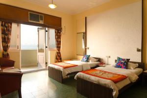 孟买南海绿色酒店 的酒店客房设有两张床和一个阳台。