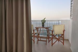 赫索尼索斯Sea Breeze Hotel的阳台配有桌椅。