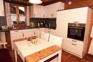 希明格Ferienwohnung Sternschnuppe的厨房配有白色橱柜和碗桌