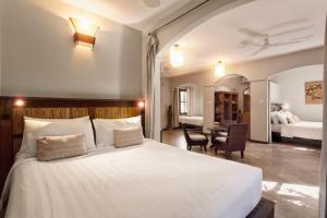 暹粒吴哥棕榈园酒店的卧室配有一张白色大床和一张书桌