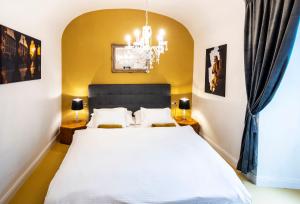 奥洛穆茨Silvie Apartments - Blažejský的卧室配有白色的床和吊灯。