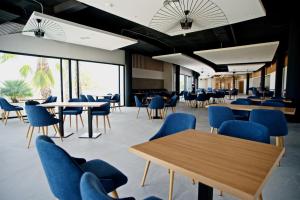 佩德雷尔Syncrosfera Fitness & Health Hotel Boutique的一间设有蓝色椅子、桌子和窗户的自助餐厅