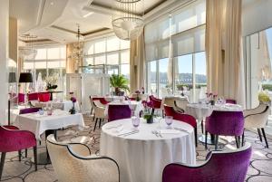 圣让-德吕兹海水浴温泉大酒店的餐厅配有白色桌子和紫色椅子