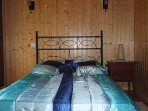 ObregónCasa para vacaciones junto al Parque de la Naturaleza de Cabarceno的卧室内的一张床铺,设有木墙