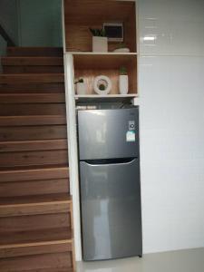 清刊บ้านขวัญกมล的楼梯旁的厨房里的一个冰箱