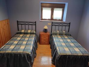 IbilcietaCasa Jauregui的客房设有两张床、一张桌子和一扇窗户。