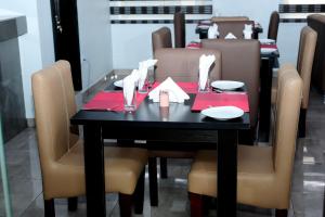 拉各斯Mariners Suites Lagos的餐桌、椅子和红色餐巾的黑桌