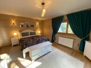 布朗喀尔巴阡木屋酒店的一间卧室配有一张带蓝色窗帘的大床