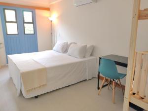 维拉维尔哈Pousada VilaZinha的卧室配有白色的床和蓝色的门