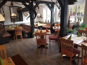 绍普夫海姆Andi´s Steakhüsli & Hotel的餐厅设有木桌、椅子和窗户。