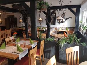 绍普夫海姆Andi´s Steakhüsli & Hotel的餐厅设有木桌和椅子,种有植物
