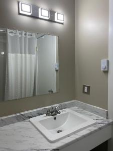 One Hundred Mile House帝国汽车旅馆的一间带水槽和大镜子的浴室