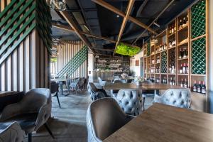 科帕奥尼克Vidik Residence的一间带木桌椅的餐厅和一间酒吧