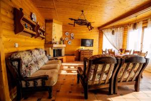 MarkovtsyCountry house Domik v derevne的小屋内的客厅配有沙发和椅子